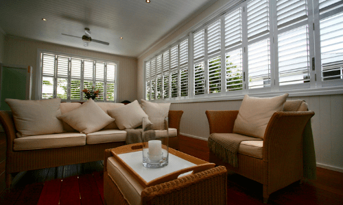 Sofa in front of a window | Featured image for Aluminium Shutters Brisbane – A Sturdy Way to Protect Your Home Cosmopolitan Shutters