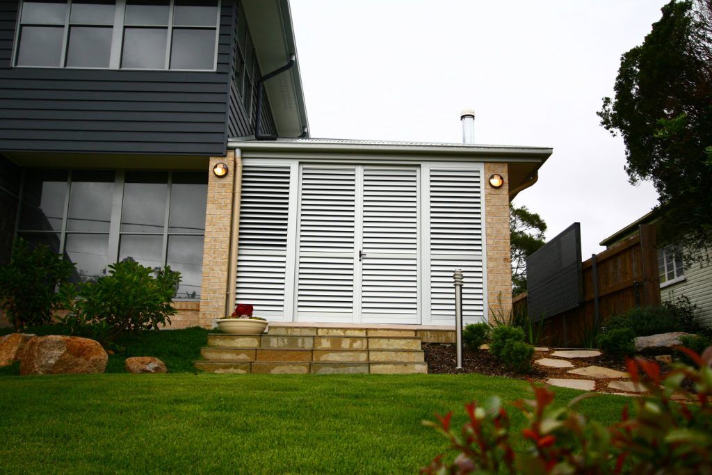 Lawn in front of a house | Featured image for Shutters: A Simple Yet Stylish Way to Keep Cool Cosmopolitan Shutters