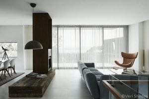 Luxury living room with white shades | Featured image for the How to Choose Between Blinds and Curtains blog from Cosmopolitan Shutters.