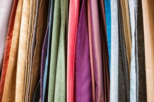 Variety of the best curtain fabrics available | Featured image for the Choosing the Best Curtain Fabrics blog from Cosmopolitan Shutters.