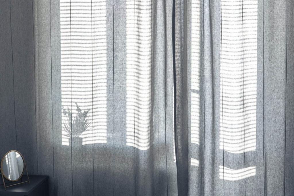 Room with curtains and shutters | Featured image for the Blog on How To Pair Plantation Shutters with Curtains from Cosmopolitan Shutters.